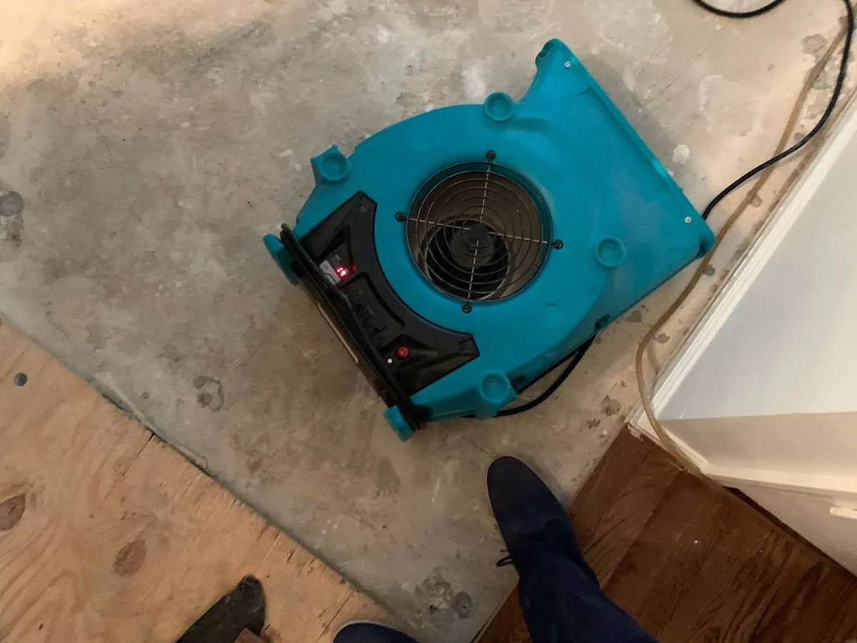 Air mover drying subfloor during Leak Detection & Repair in Stowe